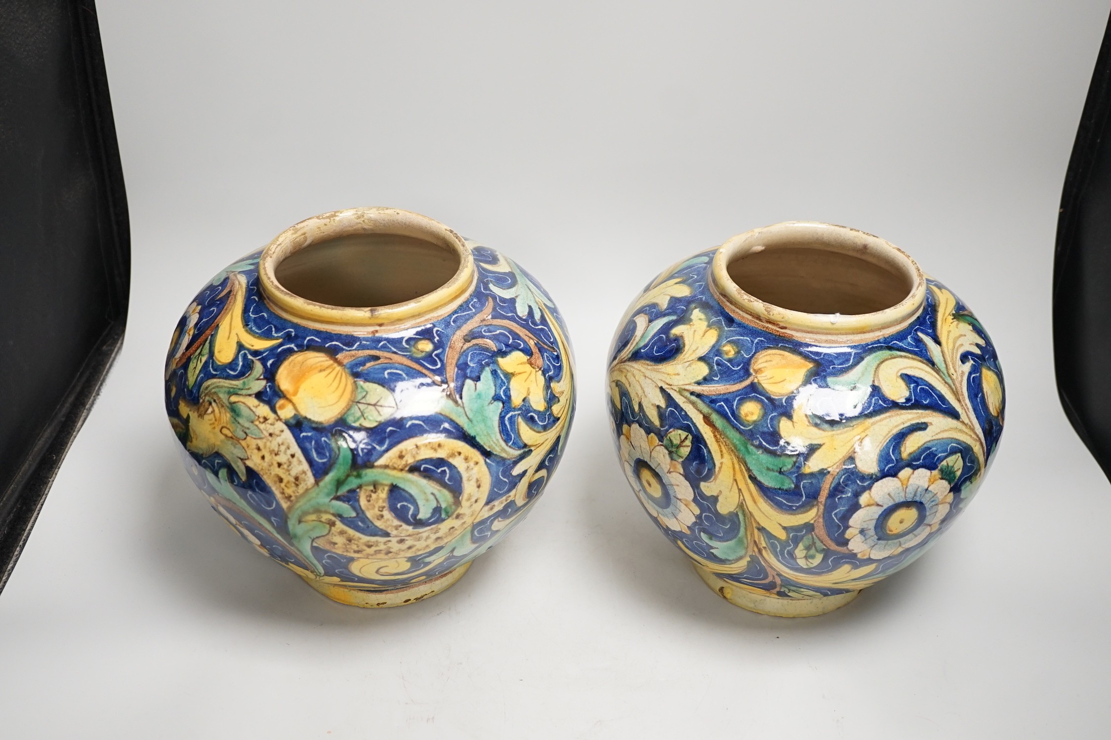 A pair of Italian maiolica flower and fruit painted jars, 22cm tall